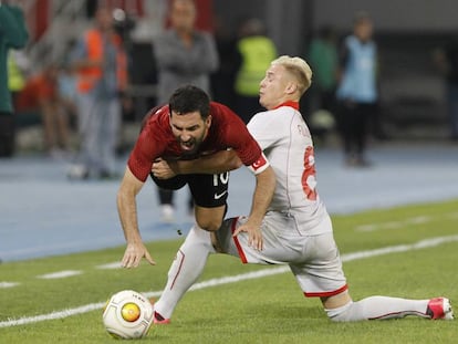 Turkey's Arda Turan, center, is challenged by Macedonia's Ezgjan Alioski, right, during an international friendly soccer match at the Philip II National Stadium in Skopje, Macedonia, on Monday, June 5, 2017. (AP Photo/Boris Grdanoski)