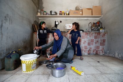Yasmine Al Saleh spült mit ihren Töchtern Aya (links) und Nour Geschirr, nachdem sie und ihre Familie am 3. Juni in ihr Haus in Al Qaryatayn zurückgekehrt sind.