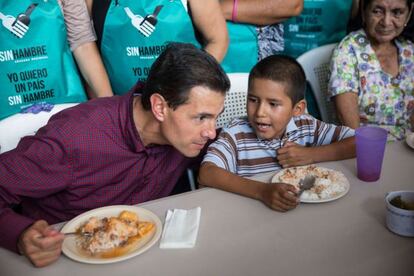 El presidente de México, Enrique Peña Nieto, habla con un niño durante una gira de trabajo en Michoacán realizada este martes.