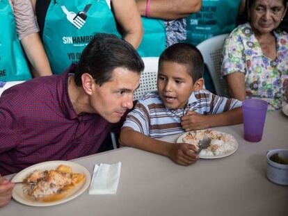 El presidente de México, Enrique Peña Nieto, habla con un niño durante una gira de trabajo en Michoacán realizada este martes.