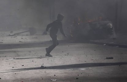 Un manifestante corre durante los choques con la policía en la capital de Túnez.