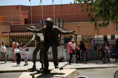 Un colegio en la Avenida Juan Carlos I de Parla, junto a la estatua de unos niños en monopatín.