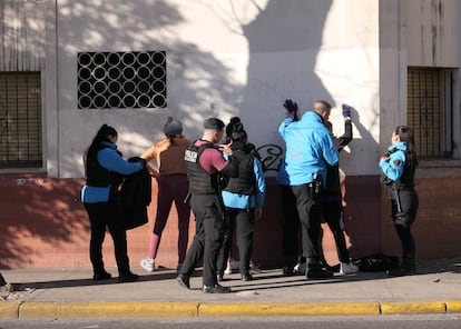 Policías revisan a sospechosos de robo en las calles del barrio.