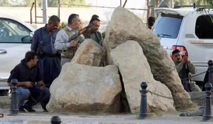 Forças ‘peshmergas’ curdas abrigadas atrás de pedras nesta sexta-feira em Kirkuk (Iraque).