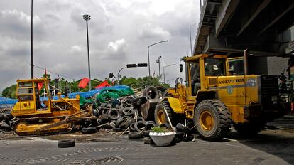 Maquinaria pesada retira las barricadas a las puertas del campamento establecido por los <i>camisas rojas</i>.