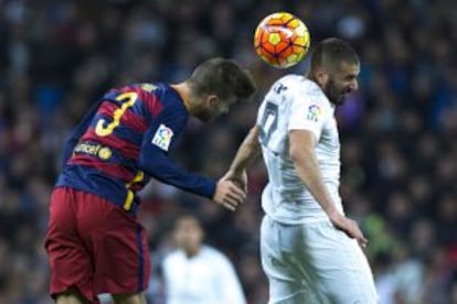 Piqué lluita amb Benzema per una pilota aèria.