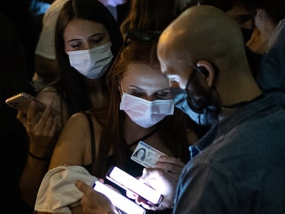 Un trabajador de una discoteca escanéa el código QR del móvil de una joven, en octubre en Barcelona.