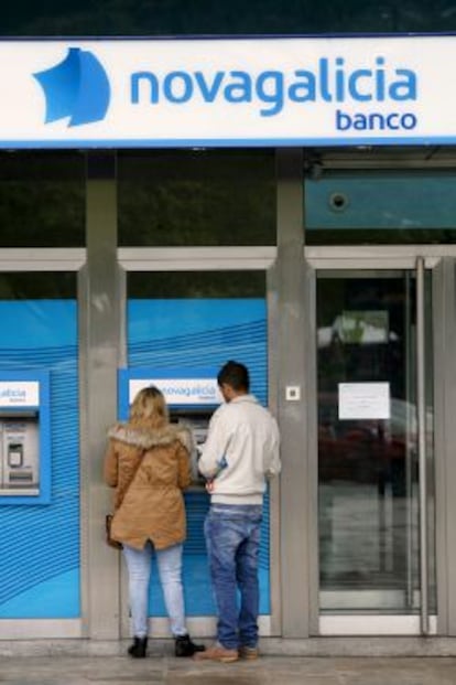 Dos clientes retiran dinero de un cajero de NCG Banco en A Coru&ntilde;a. 