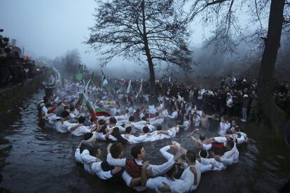 Jóvenes búlgaros interpretan la danza tradicional "Horo" en las gélidas aguas de un río para celebrar la Epifanía, en la ciudad de Kalofer, a unos 150 km de Sofía (Bulgaria).