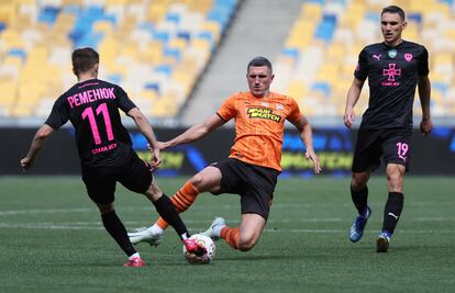 Sergiy Kryvtsov, del Shakhtar, trata de jugar el balón ante la presión de Remenyuk y Zubkov, del Metalist.