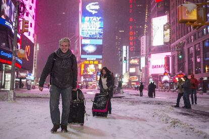 Dos turistas bajo la nieve en Times Square.
