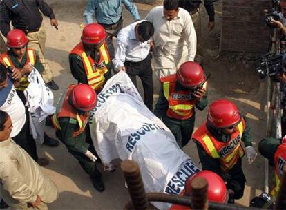 Voluntarios paquistaníes trasladan el cuerpo sin vida de un hombre en Lahore.