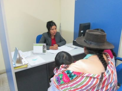 A worker at a public agency in Ayacucho speaks Quecha with a local resident.