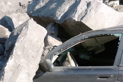 Las rocas caídas en el desprendimiento han dejado prácticamente enterrado este coche. Por fortuna, el habitáculo del vehículo no ha sufrido casi deformaciones, por lo que ha escapado con vida.