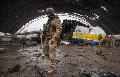 Un militar pasa frente a los restos del avión Antonov An-225.
