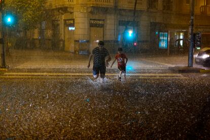 Dos peatones atraviesan un paso de cebra en Pamplona, el viernes. 