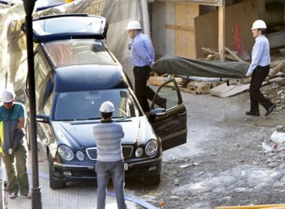 Dos hombres trasladan el cadáver del trabajador.