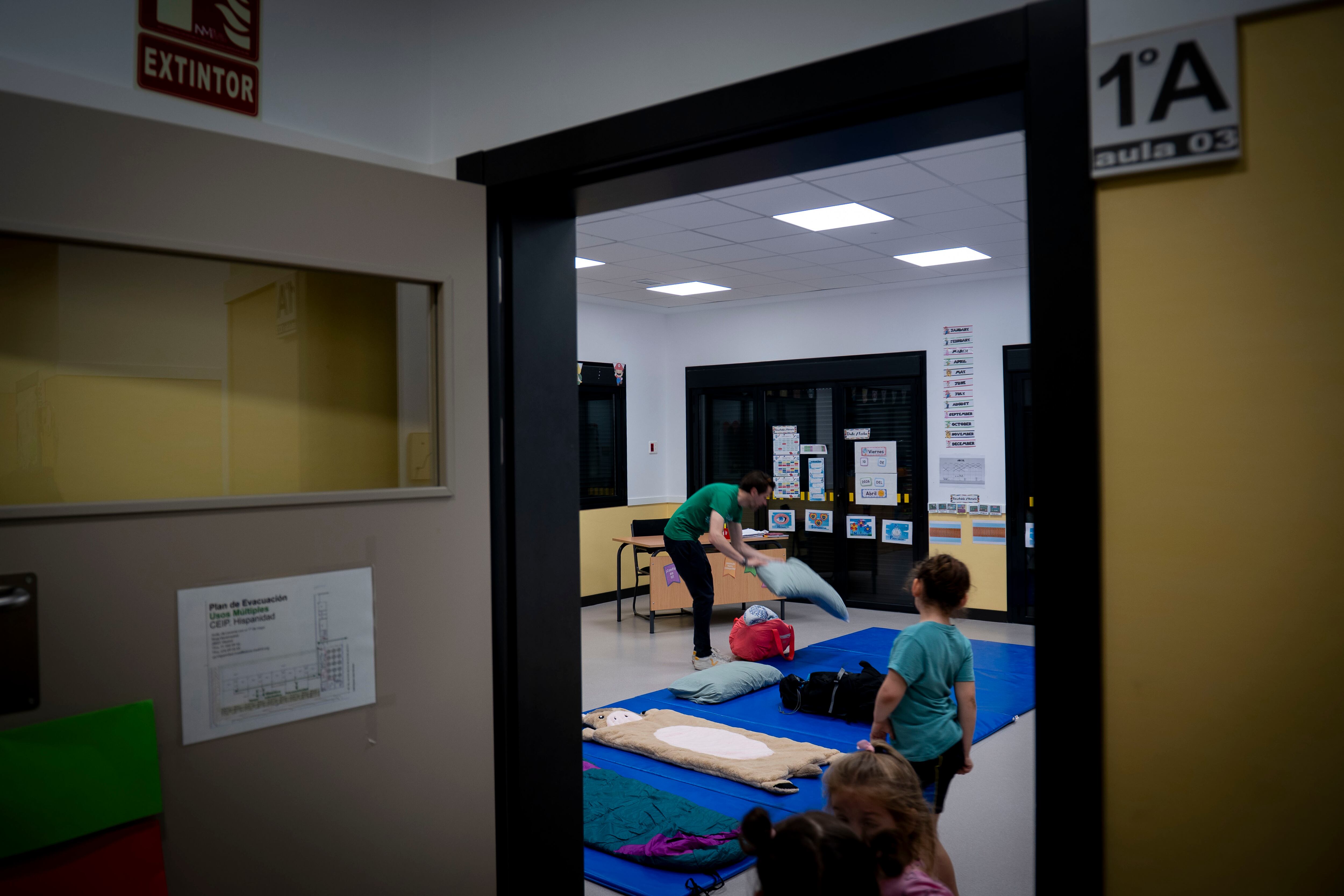 Un padre prepara las colchonetas en las que pasarán la noche las familias del CEIP Hispanidad.