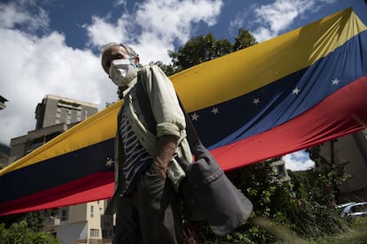 Una persona con una máscara protectora camina hacia un centro de votación durante un plebiscito liderado por la oposición en el barrio Terrazas del Ávila de Caracas, Venezuela, el sábado 12 de diciembre de 2020.