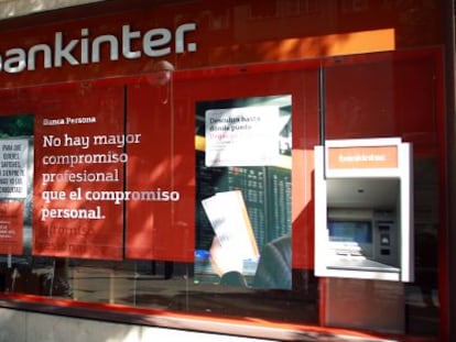 Una mujer camina frente a una sucursal de Bankinter.