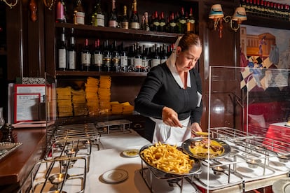 Una mesera sirve el el entrecot con papas a la francesa en Le Relais de Venise, en Ciudad de México.