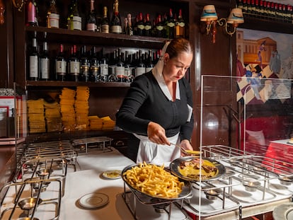 Una mesera sirve el el entrecot con papas a la francesa en Le Relais de Venise, en Ciudad de México.