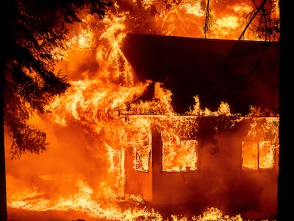 El incendio que empezó en Dixie amenaza con destruir hasta 10.000 edificios, como el que se aprecia en esta imagen de este domingo