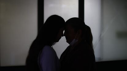 Laura B., víctima de violencia de género, y su madre Ruth se abrazan en la Comisaría de Familia de la localidad de Engátiva, Bogotá, el 11 de junio.