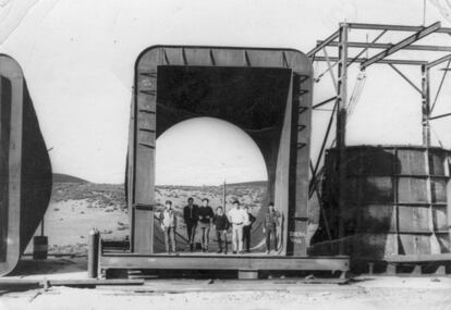 Un grupo de trabajadores posan para una foto en la compuerta de la presa, durante la fase de construcción.