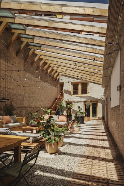 El patio central de la casa actúa como un pulmón verde desprovisto de cualquier revestimiento. Se trata de un espacio flexible que puede acoger un salón, una sala de cine con proyector o incluso una zona exterior donde meditar y hacer yoga.