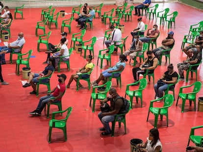 Varias personas esperan para recibir sus vacunas contra la covid-19 en el centro de vacunación del Centro Olímpico Juan Pablo Duarte en Santo Domingo, República Dominicana.