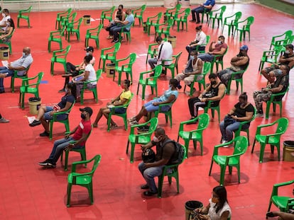 Varias personas esperan para recibir sus vacunas contra la covid-19 en el centro de vacunación del Centro Olímpico Juan Pablo Duarte en Santo Domingo, República Dominicana.