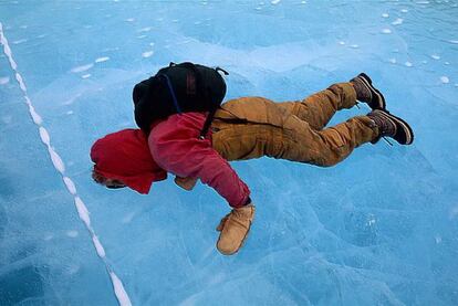 Un viajero mira a través del hielo en Mummy Pond, en la Antártida, la región del mundo donde se registran las temperaturas más bajas.