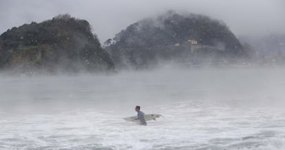 Un surfista s'endinsa a la platja d'Ondarreta de Sant Sebastià (Guipúscoa).