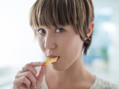 Una mujer comiendo un Dorito al uso, profundamente molesta por el ruido que está haciendo.