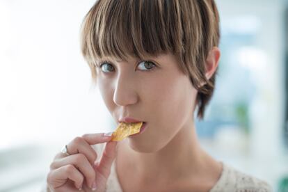 Una mujer comiendo un Dorito al uso, profundamente molesta por el ruido que está haciendo.