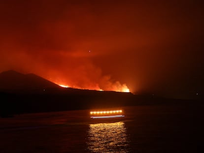 Los guardacostas pasan mientras la lava llega al mar, en una imagen tomada desde el puerto de Tazacorte.