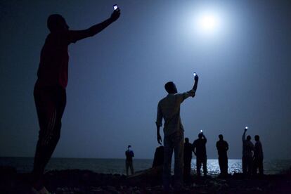 Emigrantes africanos en la costa de Djibouti intentando captar una señal telefónica con sus móviles.