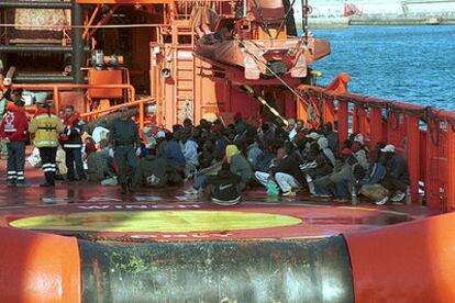 Agentes de la Guardia Civil inspeccionan el buque <i>Olomne,</i> de bandera desconocida, con 227 inmigrantes a bordo, el sábado pasado.