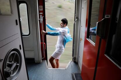 Sinan Usta, de 24 años, posa para un selfie en una puerta abierta mientras el tren va en marcha. 