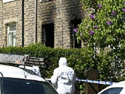 La policía examina la casa de Huddersfield después del incendio.