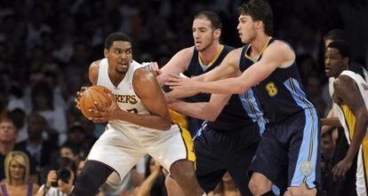 Bynum, de los Lakers, controla la bola ante Koufos y Gallinari de los Nuggets.