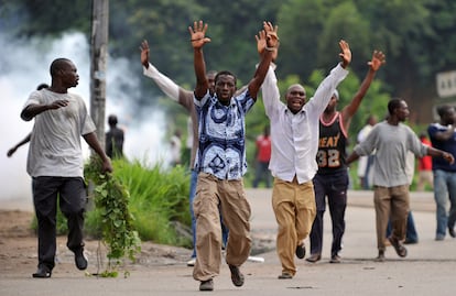 Un grupo de partidarios de Alsssane Ouattara, hacen señales de rendición frente a las tropas leales a Gbagbo.