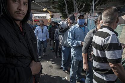 Migrantes hacen fila para desayunar en la única cocina que hay en el campamento.