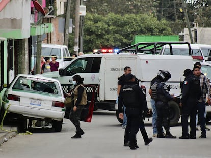 Miembros de la policía municipal y agentes periciales inspeccionan el sitio donde fue asesinado el periodista.