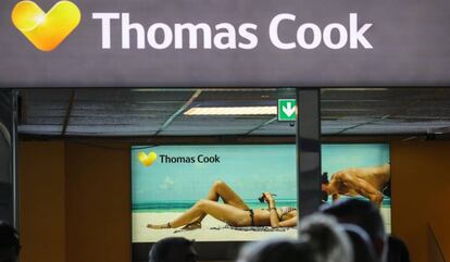 Pasajeros delante de un cartel publicitario de Thomas Cook en el aeropuerto de Francfort.