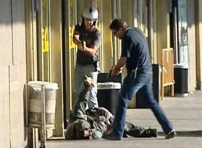 Dos agentes apuntan al indigente herido ayer en el aeropuerto de Barajas.