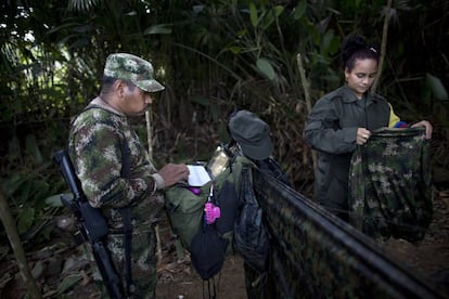 Juan Pablo, un comandante del frente 36 de las fuerzas armadas revolucionarias de Colombia, FARC, consulta su portátil, junto a su novia, la combatiente rebelde de 25 años de edad Tania, en un campo oculto en el estado de Antioquia, en los Andes del noroeste de Colombia.