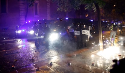 Los manifestantes lanzan material pirotécnico contra la policía en la calle Ferraz de Madrid, junto a la sede del PSOE.
