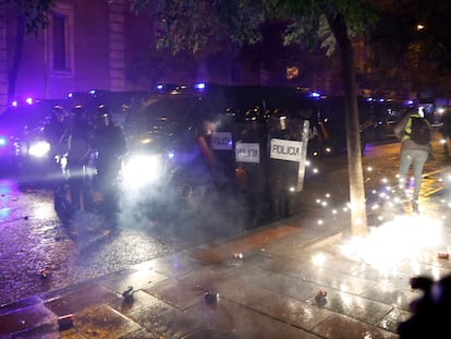 Los manifestantes lanzan material pirotécnico contra la policía en la calle Ferraz de Madrid, junto a la sede del PSOE.